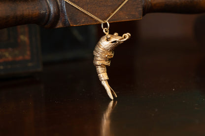 9ct yellow gold articulated shrimp pendant charm with segmented body hanging against a dark background.