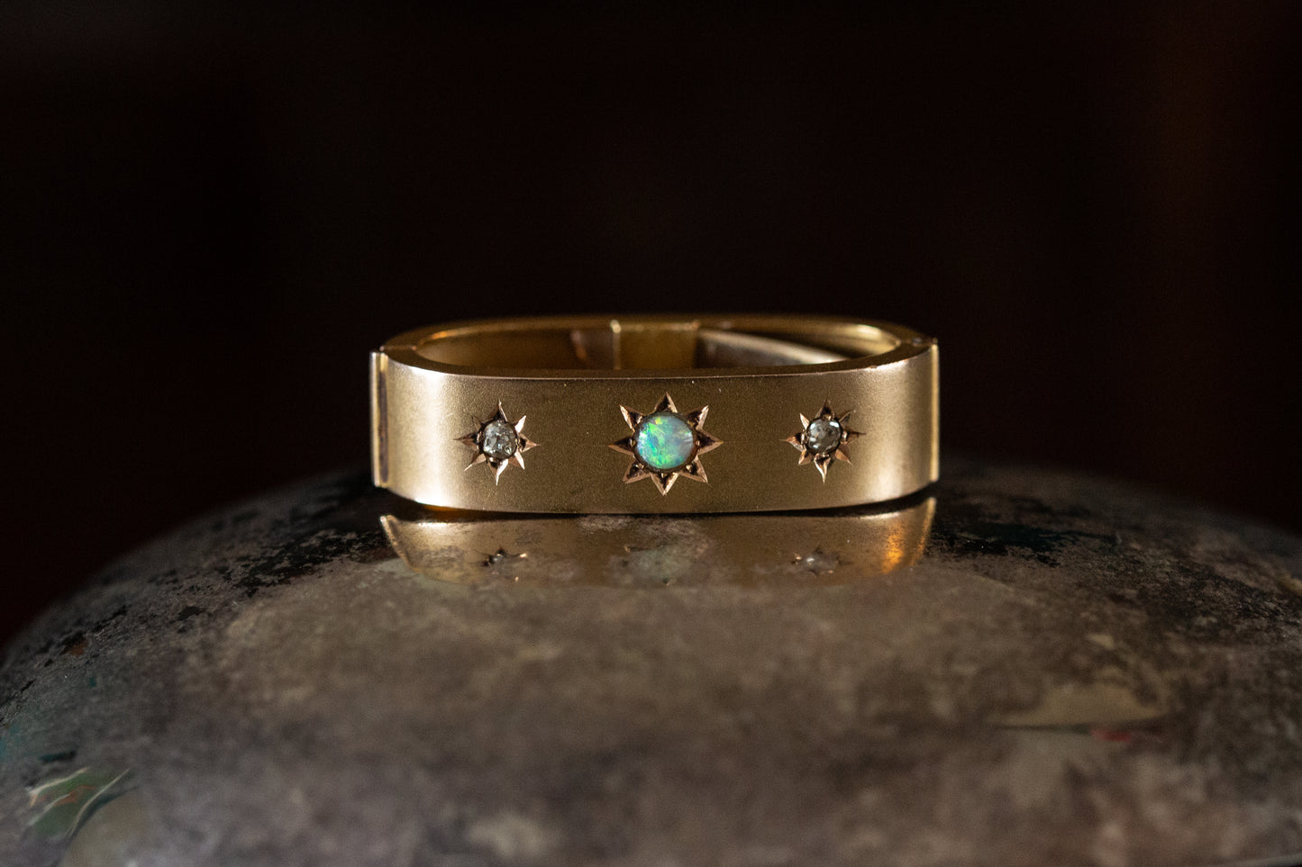 Front view of Edwardian 15ct yellow gold scarf clip featuring a central star-set opal flanked by two star-set diamonds.