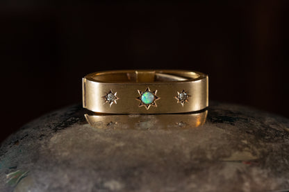 Front view of Edwardian 15ct yellow gold scarf clip featuring a central star-set opal flanked by two star-set diamonds.