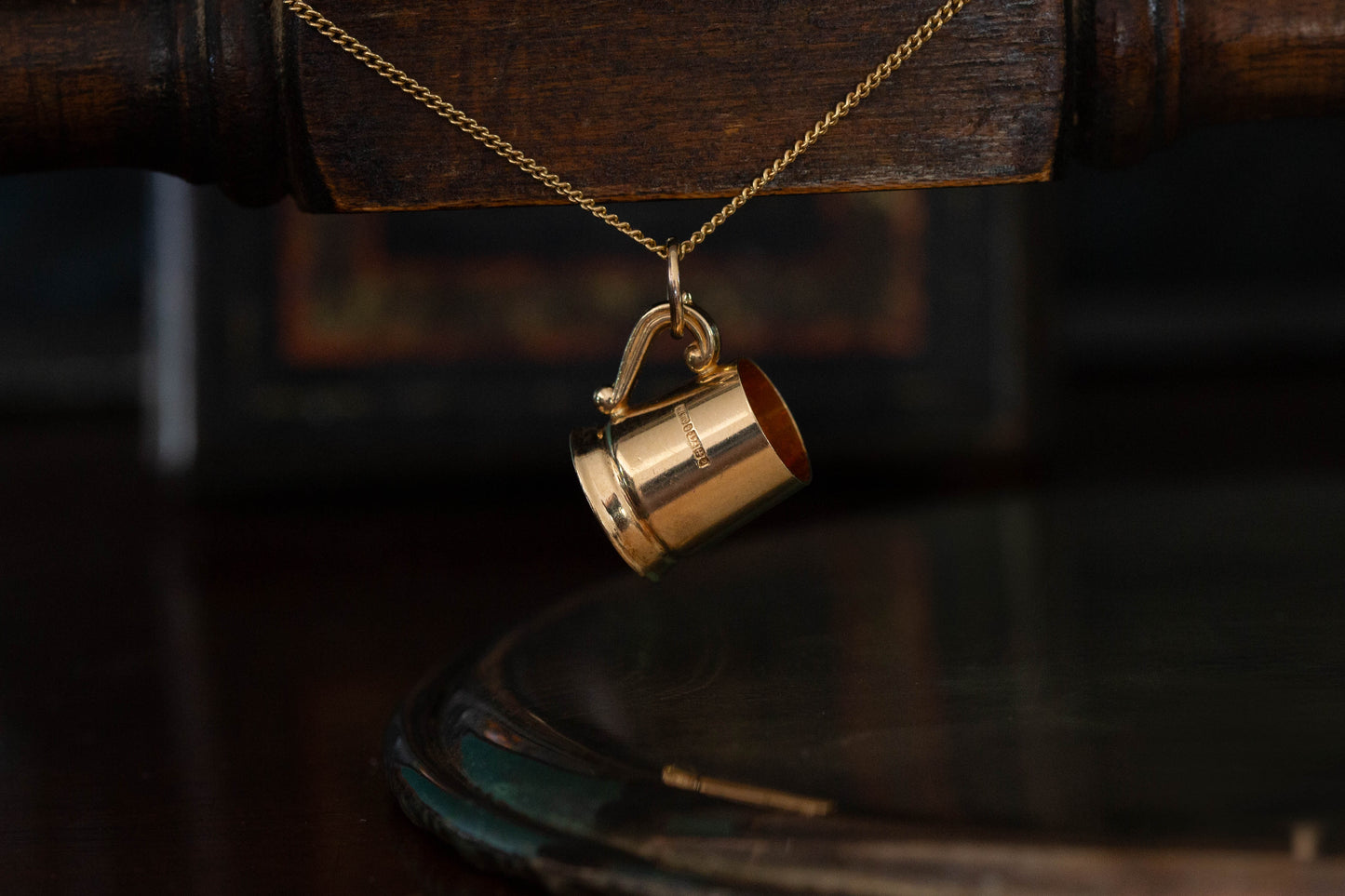 9ct yellow gold tankard pendant charm hanging against a dark background.