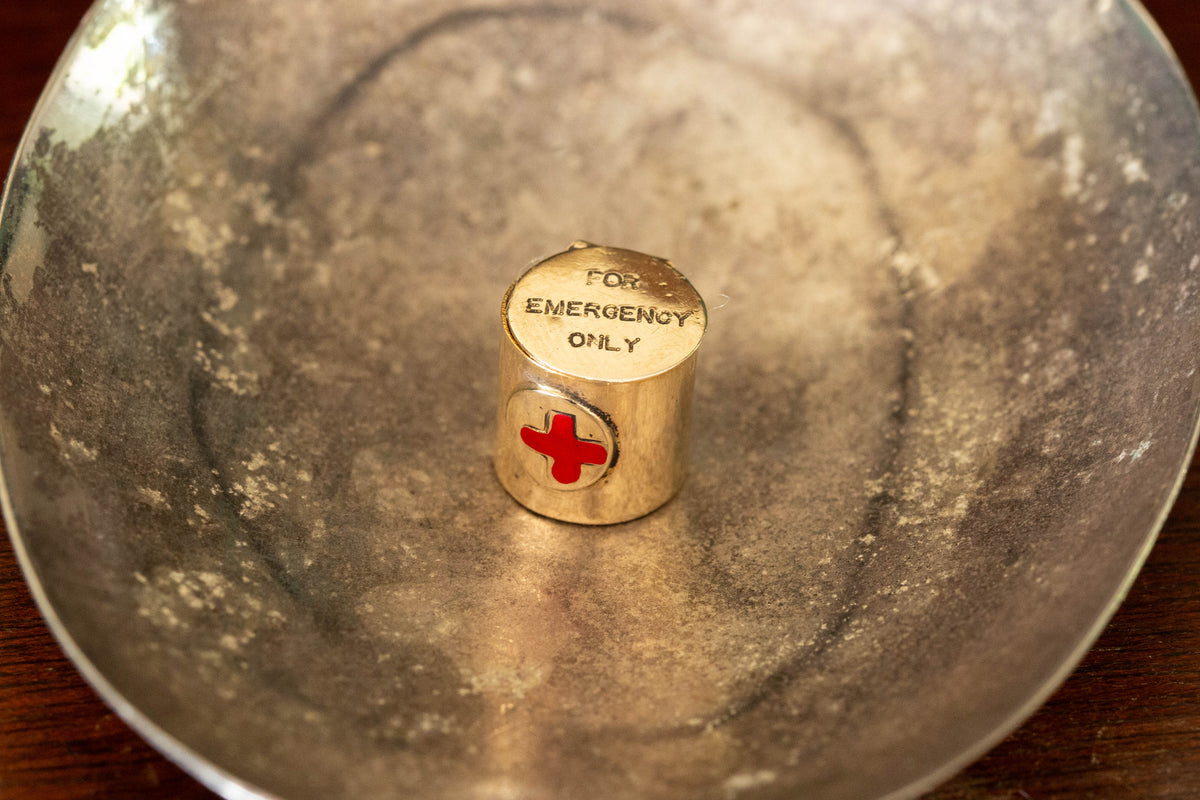 9ct yellow gold canister pendant with articulated lid and red cross, engraved "FOR EMERGENCY ONLY".