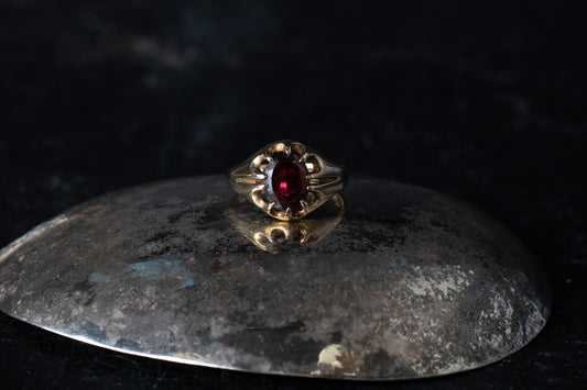 Gents 9ct yellow gold solitaire ring featuring a deep red oval garnet in an openwork split shoulder setting.