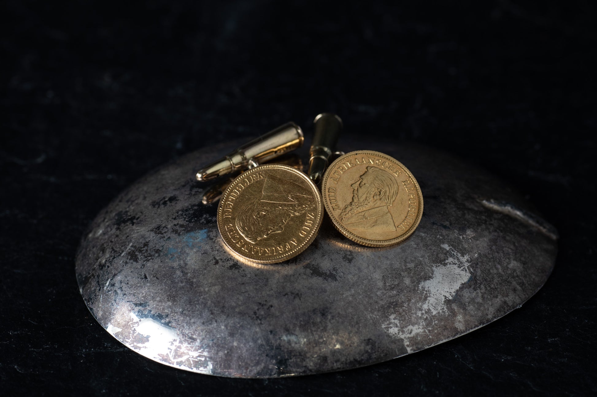 Pair of 22ct yellow gold cufflinks featuring 1896 South African half pound coins and bullet-shaped toggles.