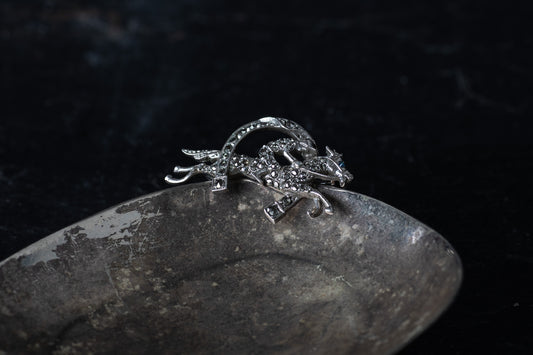 Vintage silver brooch depicting a horse and jockey leaping over a fence, pave set with sparkling marcasite stones.