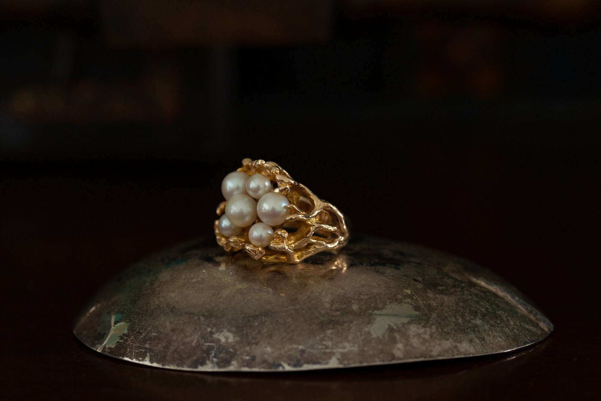 Side view of 10ct yellow gold ring featuring a cluster of white pearls in a textured organic setting on dark background.